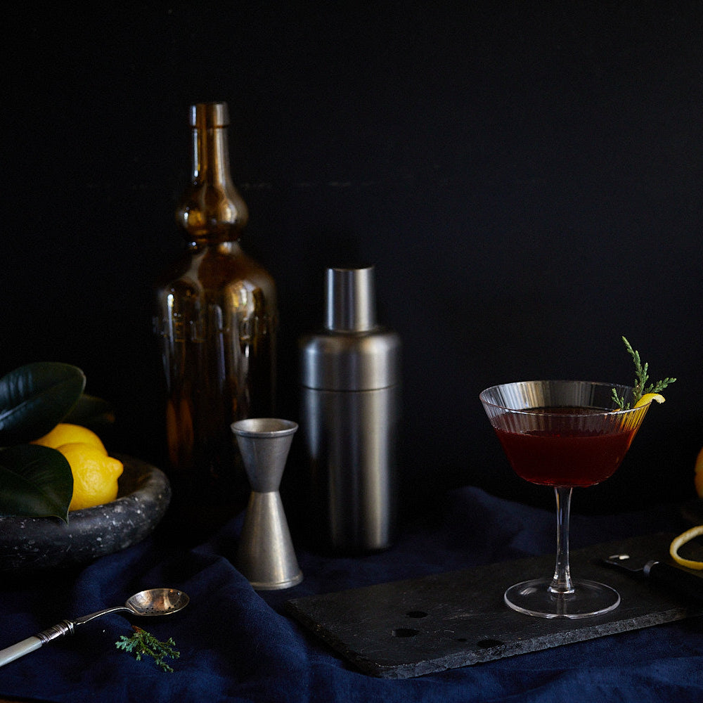 moody tablescape of cocktail and shaker